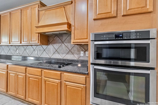 kitchen featuring custom range hood, black stovetop, backsplash, and stainless steel double oven