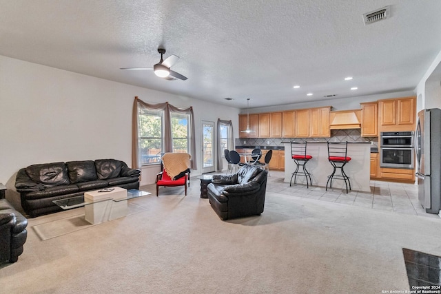 carpeted living room with a textured ceiling and ceiling fan