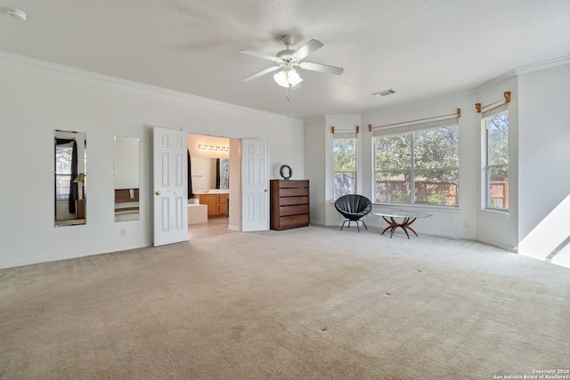 interior space featuring ornamental molding, ensuite bathroom, light colored carpet, and ceiling fan