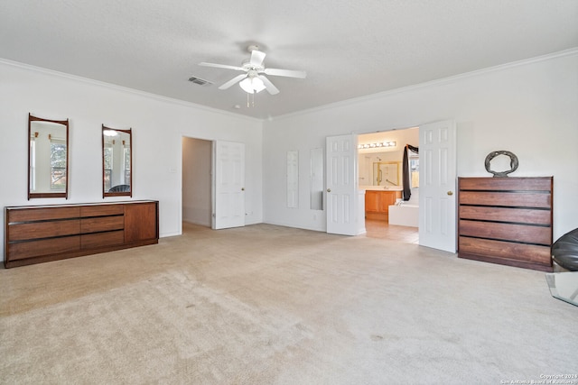 unfurnished bedroom featuring light carpet, ornamental molding, ensuite bath, and ceiling fan