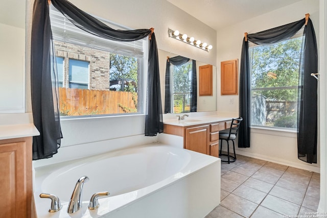 bathroom featuring vanity, tile patterned flooring, a bath, and plenty of natural light