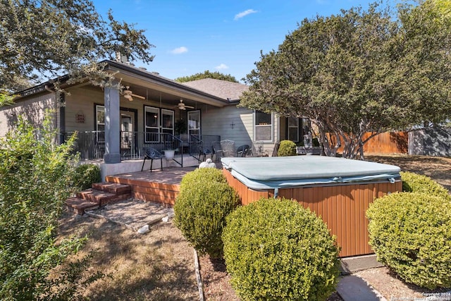 back of property with a hot tub and a porch