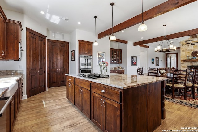 kitchen with light wood-type flooring, a center island, stainless steel appliances, pendant lighting, and beam ceiling