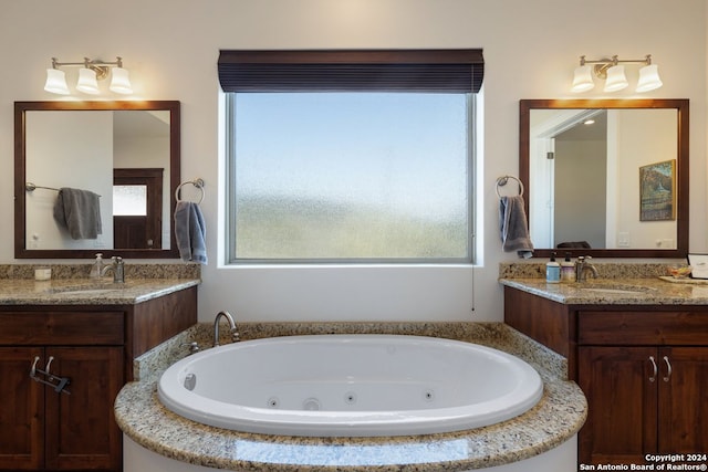 bathroom featuring vanity and tiled tub