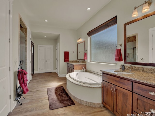 bathroom with vanity, separate shower and tub, and hardwood / wood-style floors