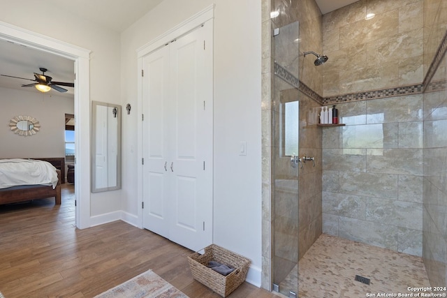 bathroom featuring ceiling fan, hardwood / wood-style flooring, and tiled shower