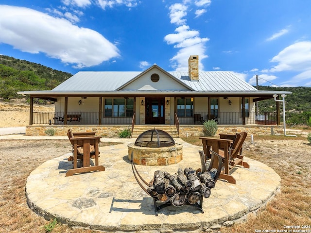 back of property with a patio, ceiling fan, and a fire pit