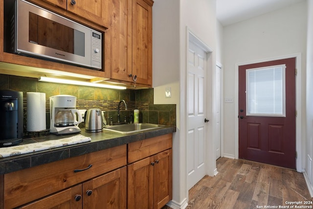 kitchen with sink, tasteful backsplash, stainless steel microwave, and dark hardwood / wood-style floors