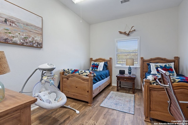 bedroom featuring vaulted ceiling and hardwood / wood-style flooring