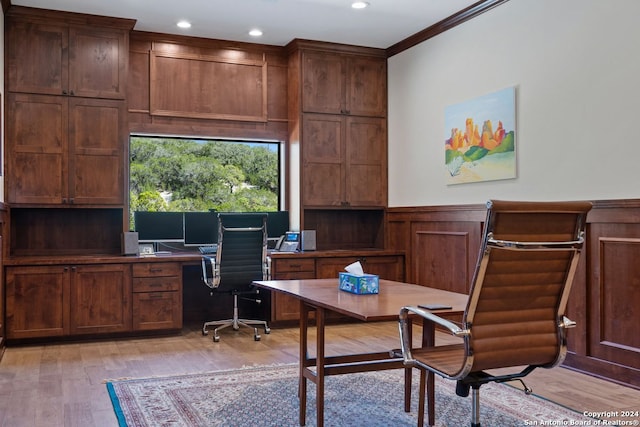 office featuring built in desk, ornamental molding, and light wood-type flooring