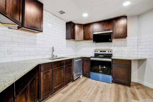 kitchen with light hardwood / wood-style flooring, backsplash, sink, light stone countertops, and appliances with stainless steel finishes