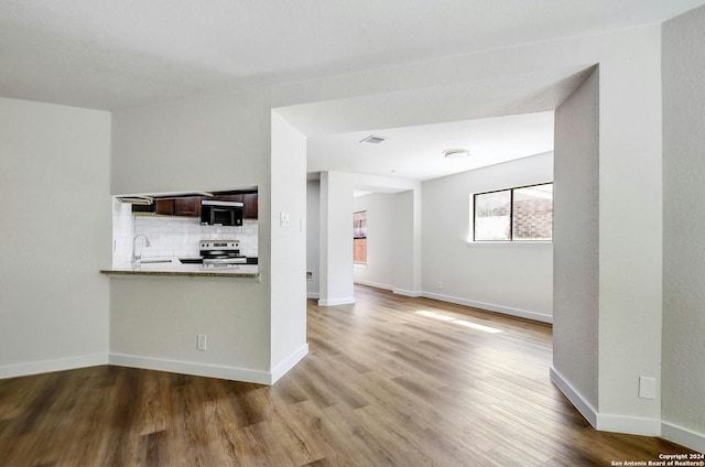 unfurnished living room with hardwood / wood-style flooring and sink