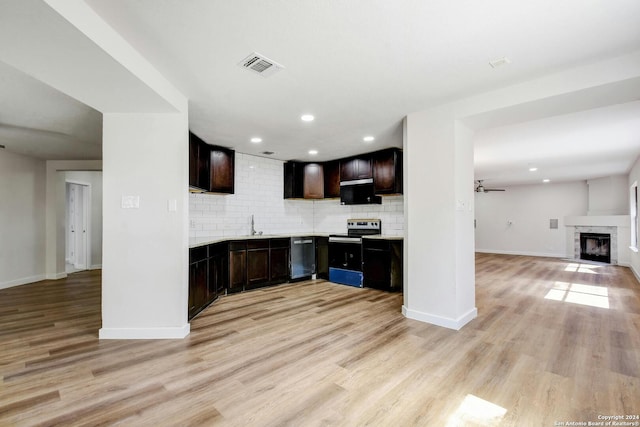 kitchen with light hardwood / wood-style floors, stainless steel appliances, decorative backsplash, and ceiling fan