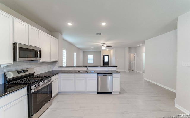 6523 Scooby Acres, San Antonio, TX 78253 - kitchen with stainless steel appliances, a sink, a peninsula, dark countertops, and baseboards