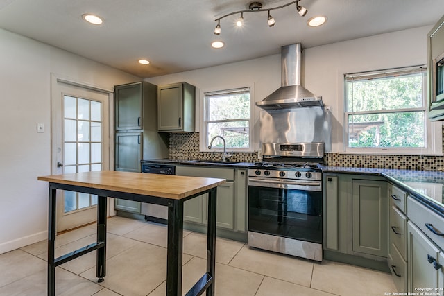 kitchen with a healthy amount of sunlight, gas range, wall chimney exhaust hood, and sink