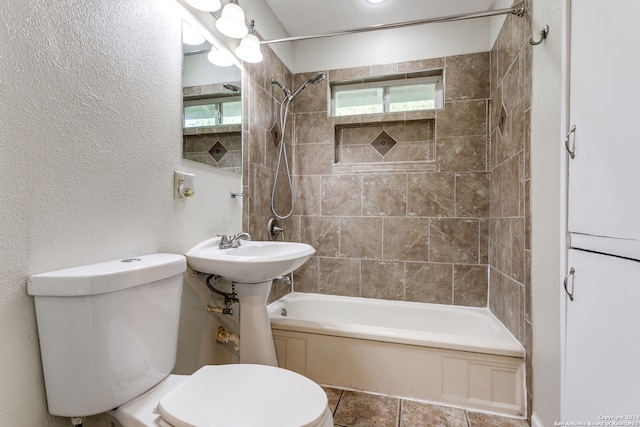 bathroom featuring tiled shower / bath combo and toilet