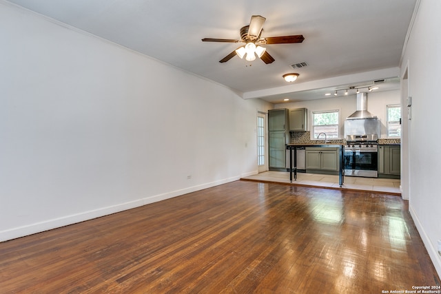 unfurnished living room featuring ceiling fan, ornamental molding, sink, and light wood-type flooring