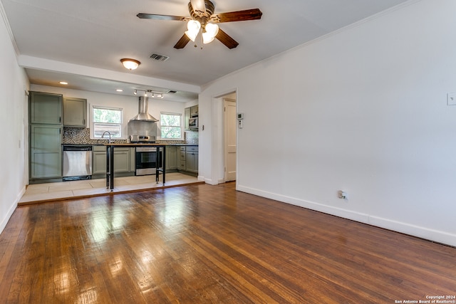 unfurnished living room featuring crown molding, hardwood / wood-style flooring, and ceiling fan