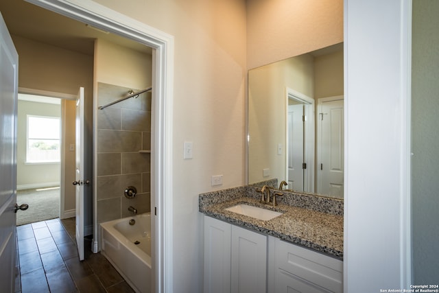 bathroom featuring vanity and tiled shower / bath