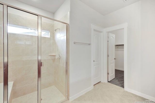 bathroom with a shower with door and tile patterned flooring