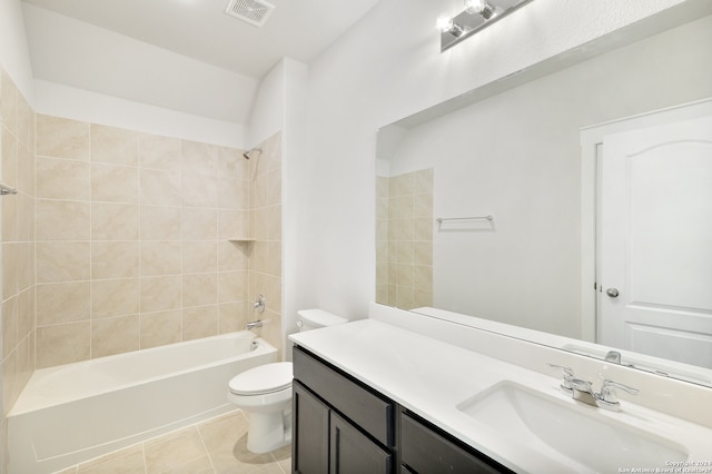 full bathroom featuring toilet, tiled shower / bath combo, vanity, and tile patterned flooring