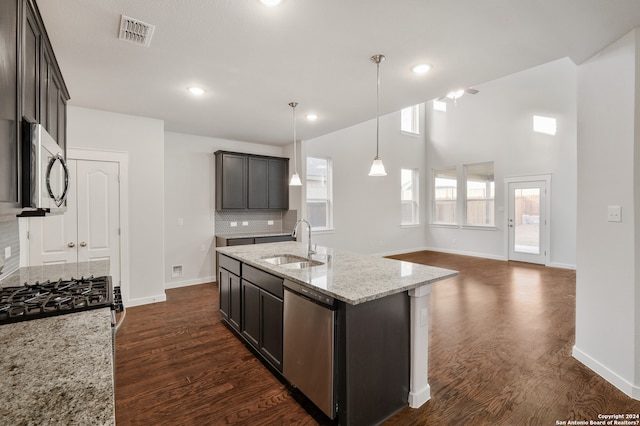 kitchen featuring stainless steel appliances, dark brown cabinets, sink, and a kitchen island with sink