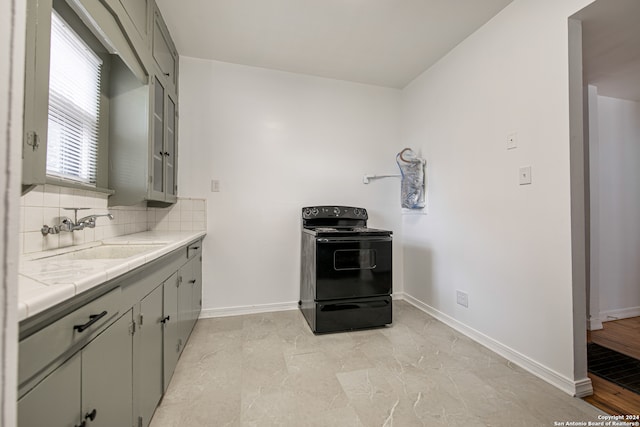 kitchen featuring tasteful backsplash, sink, electric range, tile counters, and gray cabinets