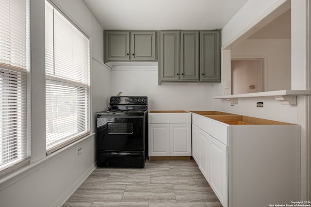 kitchen featuring black range with electric cooktop and gray cabinetry