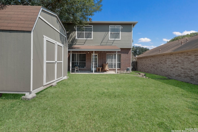 rear view of house featuring a storage shed, a yard, and a patio