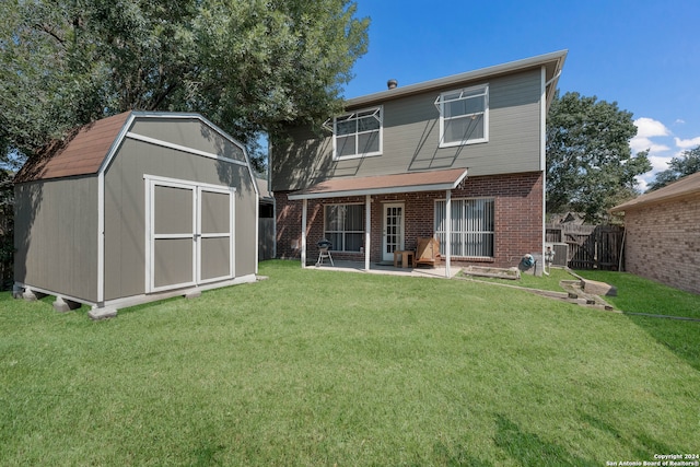 back of property with a shed, a patio area, and a lawn