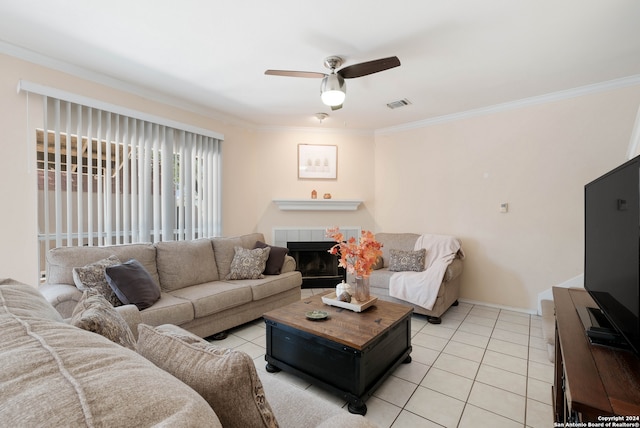 tiled living room with ceiling fan, crown molding, and a fireplace