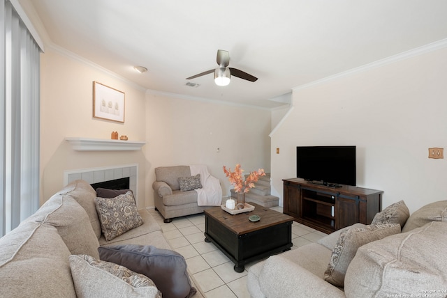 tiled living room featuring crown molding, a fireplace, and ceiling fan