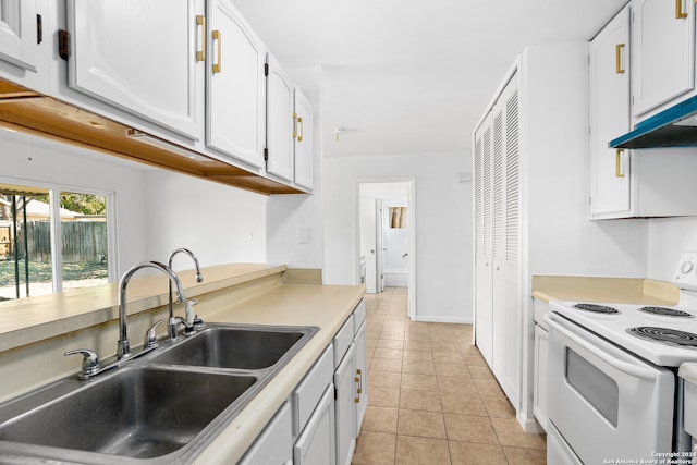 kitchen featuring white electric range oven, sink, white cabinetry, and light tile patterned floors