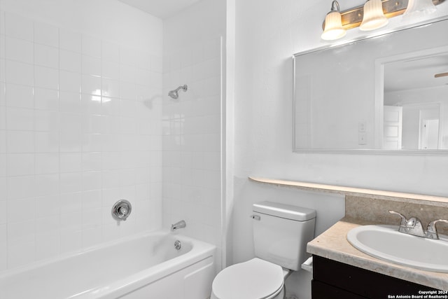 full bathroom with vanity, tiled shower / bath combo, and toilet