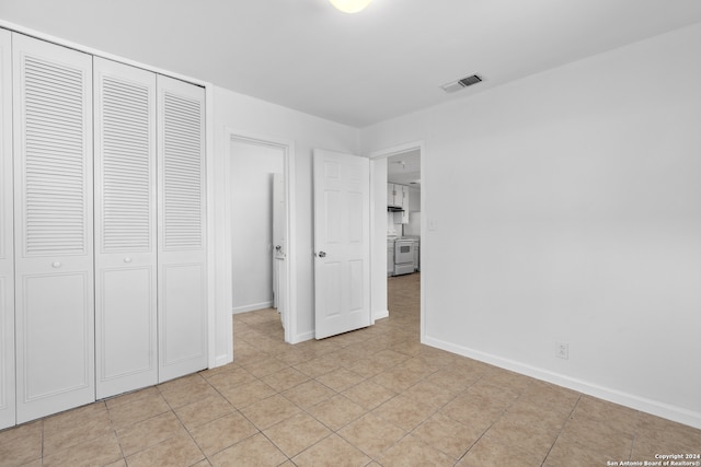 unfurnished bedroom with light tile patterned flooring and a closet