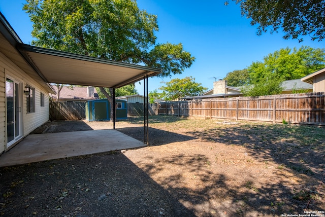 view of yard featuring a shed and a patio