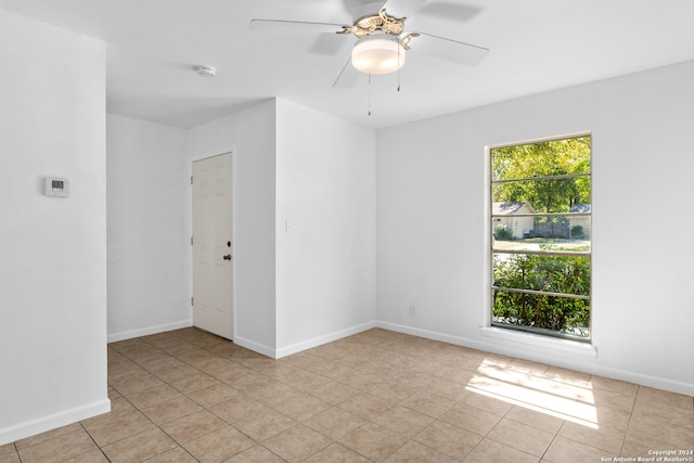 spare room featuring ceiling fan and light tile patterned flooring