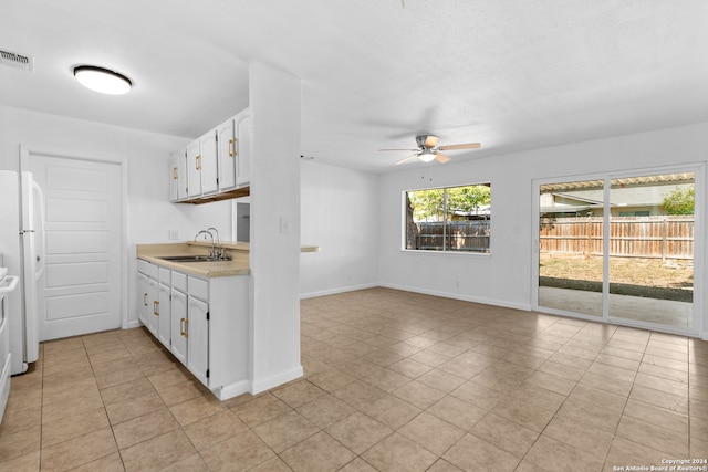 kitchen with sink, ceiling fan, white cabinets, white fridge, and light tile patterned floors