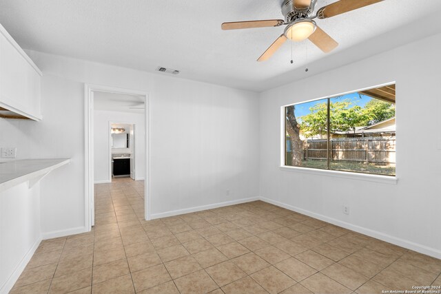 empty room with light tile patterned floors and ceiling fan