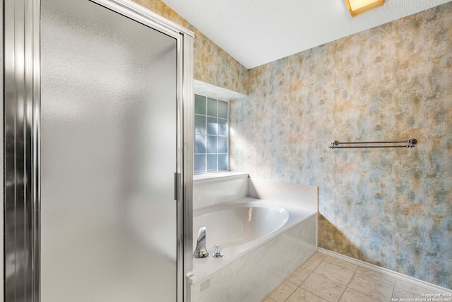 bathroom with vaulted ceiling, tile patterned flooring, and a bathing tub