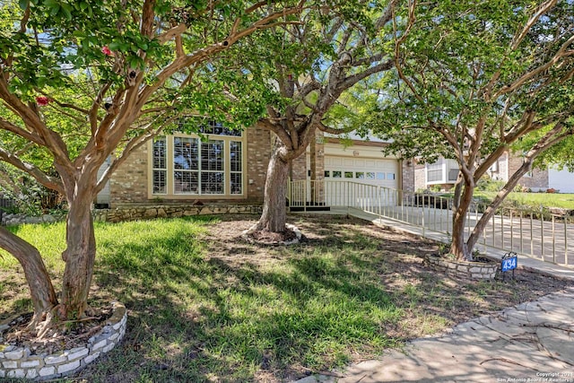 obstructed view of property featuring a garage and a front lawn