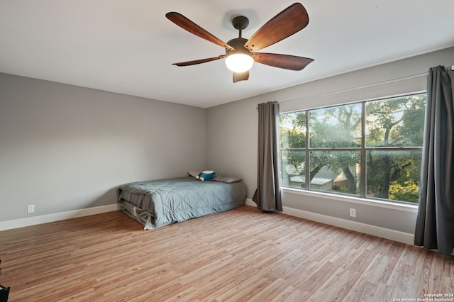 unfurnished bedroom with light hardwood / wood-style flooring, multiple windows, and ceiling fan