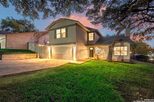 front facade with a yard and a garage