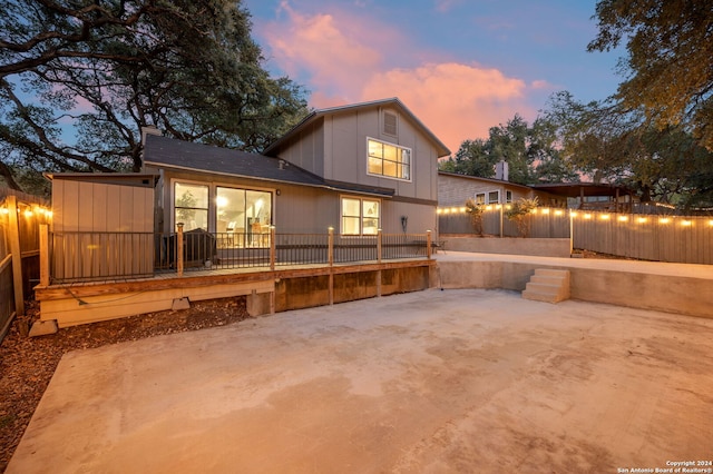 back house at dusk featuring a patio area