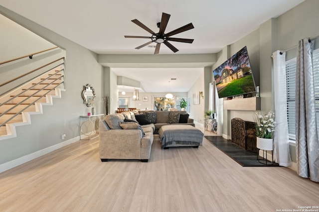 living room with lofted ceiling, light hardwood / wood-style floors, and ceiling fan