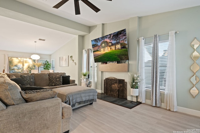 living room with lofted ceiling, hardwood / wood-style flooring, and ceiling fan