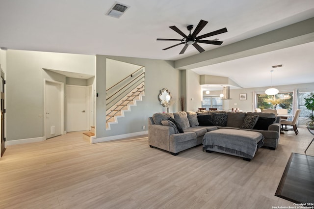 living room with lofted ceiling, light wood-type flooring, and ceiling fan