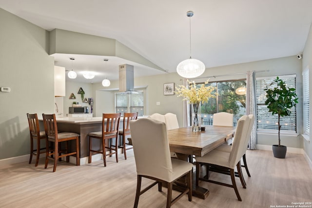 dining room with light hardwood / wood-style flooring and lofted ceiling