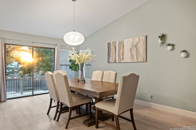 dining space featuring vaulted ceiling and light hardwood / wood-style flooring