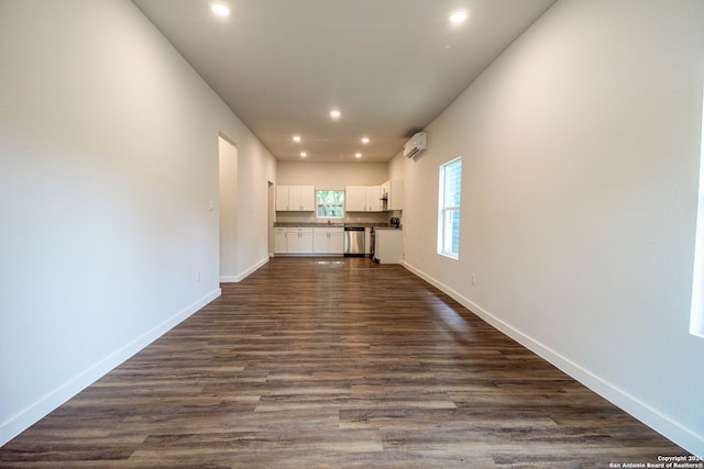 interior space with a wall mounted air conditioner and dark hardwood / wood-style floors